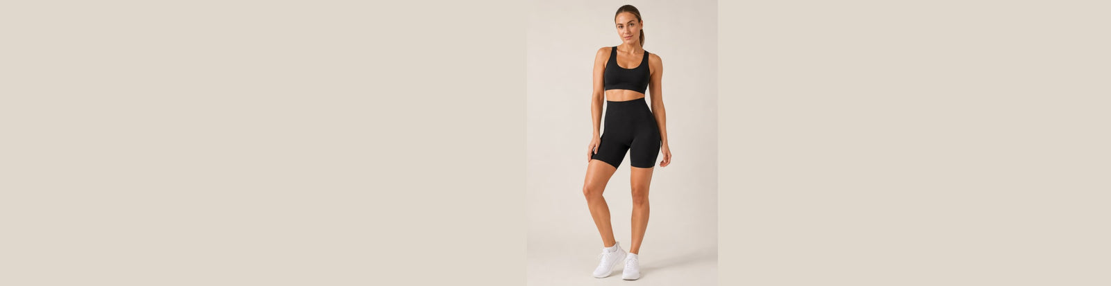 LiftLux training shorts in black, worn with a matching bra on a studio background