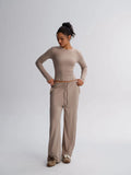 Woman wearing a beige outfit on a plain background